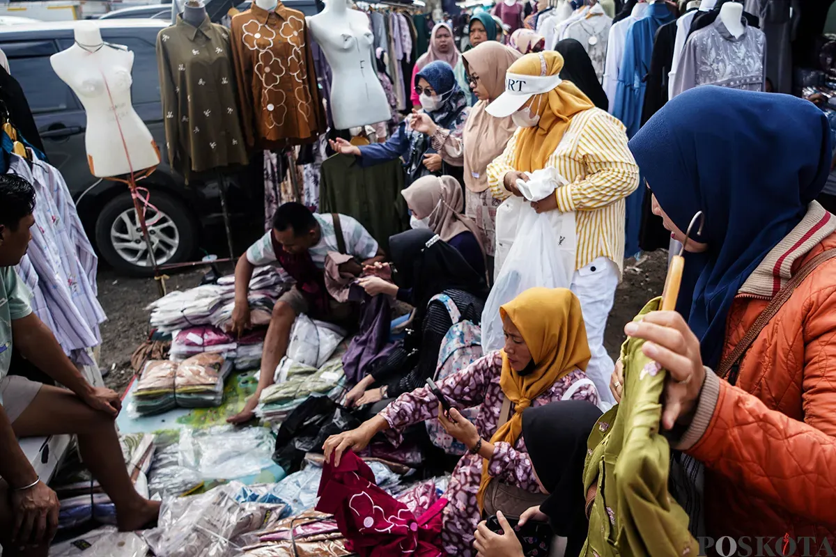 Pedagang melayani calon pembeli saat  memilih ragam busana lebaran di Pasar Tasik, Cideng, Jakarta Pusat, Kamis 20 Maret 2025. (Sumber: Poskoata/ Bilal Nugraha Ginanjar)