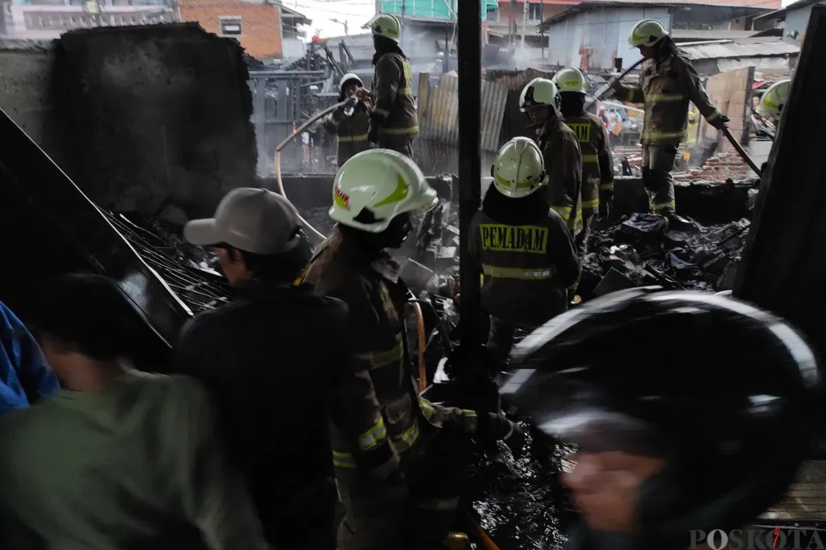 Petugas Penanggulangan Kebakaran dan Penyelamatan (Gulkarmat) Jakarta berupaya memadamkan sisa api yang tersisa pasca terjadinya musibah kebakaran yang menimpa sejumlah lapak pedagang pakaian dan lainnya di Pasar Poncol, Senen, Jakarta Pusat, Senin, 18 Maret 2025. (Sumber: Poskota/Ade Mamad)