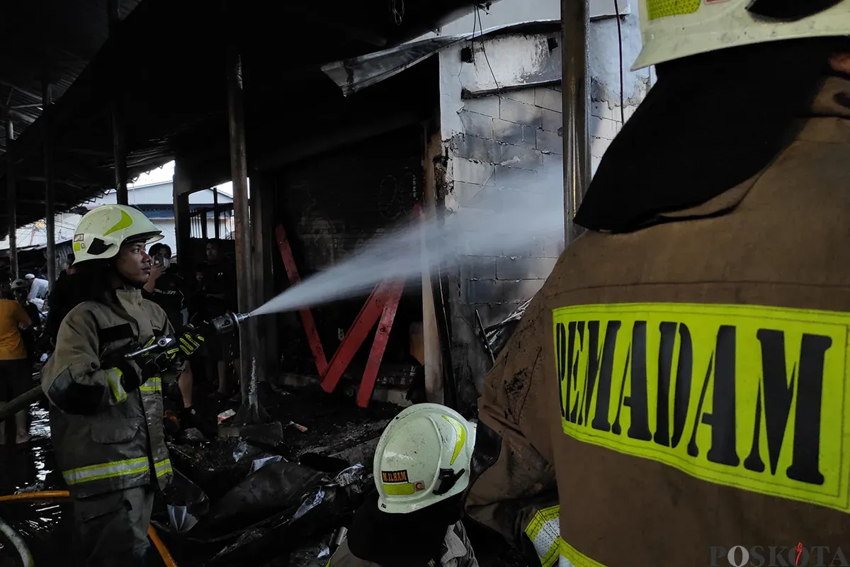 Petugas Penanggulangan Kebakaran dan Penyelamatan (Gulkarmat) Jakarta berupaya memadamkan sisa api yang tersisa pasca terjadinya musibah kebakaran yang menimpa sejumlah lapak pedagang pakaian dan lainnya di Pasar Poncol, Senen, Jakarta Pusat, Senin, 18 Maret 2025. (Sumber: Poskota/Ade Mamad)