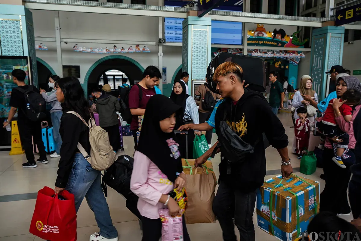 Antrean penumpang masuk ke dalam peron sambil membawa barang bawaannya di Stasiun Pasar Senen, Jakarta, Sabtu, 22 Maret 2025. (Sumber: Poskota/Bilal Nugraha Ginanjar)