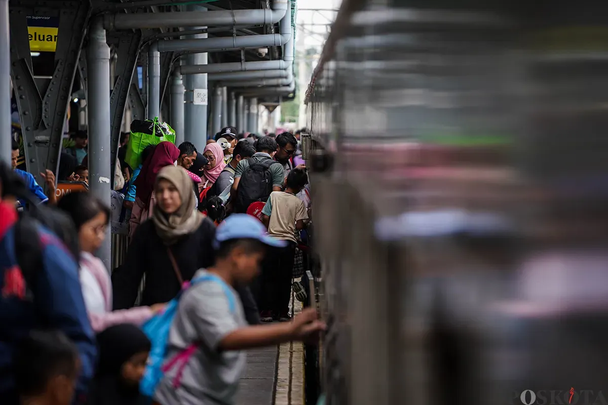 Antrean penumpang masuk ke dalam peron sambil membawa barang bawaannya di Stasiun Pasar Senen, Jakarta, Sabtu, 22 Maret 2025. (Sumber: Poskota/Bilal Nugraha Ginanjar)