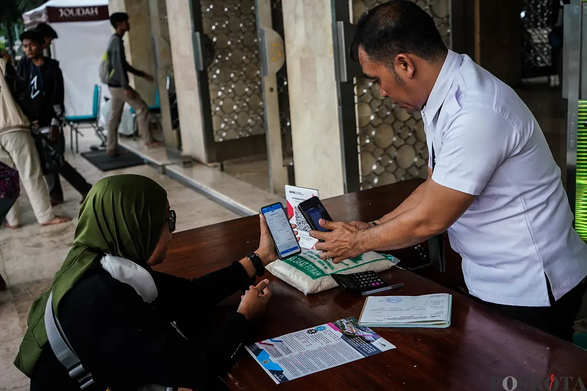 Petugas melayani sejumlah jamaah saat proses pembayaran zakat fitrah di Masjid Istiqlal, Jakarta, Senin, 24 Maret 2025. (Sumber: Poskota/Bilal Nugraha Ginanjar)