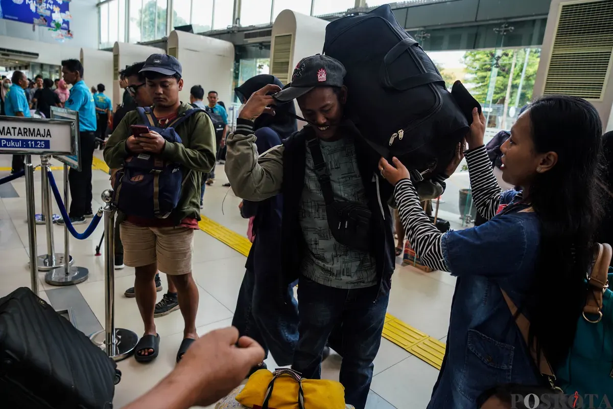 Pemudik hendak menurunkan barang bawaan saat memasuki peron Stasiun Pasar Senen, Jakarta, beberapa waktu lalu. (Sumber: Poskota/Bilal Nugraha Ginanjar)