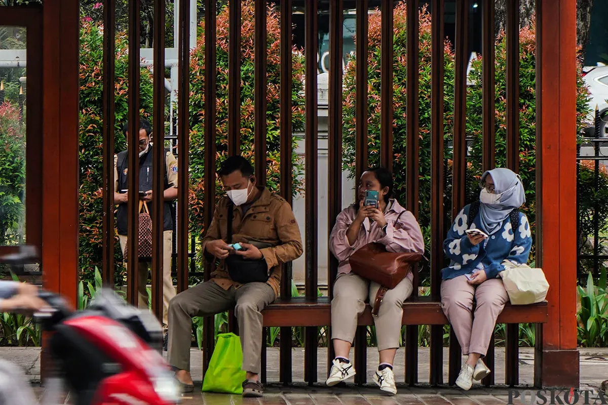Sejumlah pegawai Aparatur Sipil Negara (ASN) menunggu kedatangan bus pada jam pulang kerja di Halte DPRD di depan komplek perkantoran Balaikota Pemerintah Provinsi (Pemprov) Jakarta, Jakarta, Senin, 24 Maret 2025. (Sumber: Poskota/Bilal Nugraha Ginanjar)