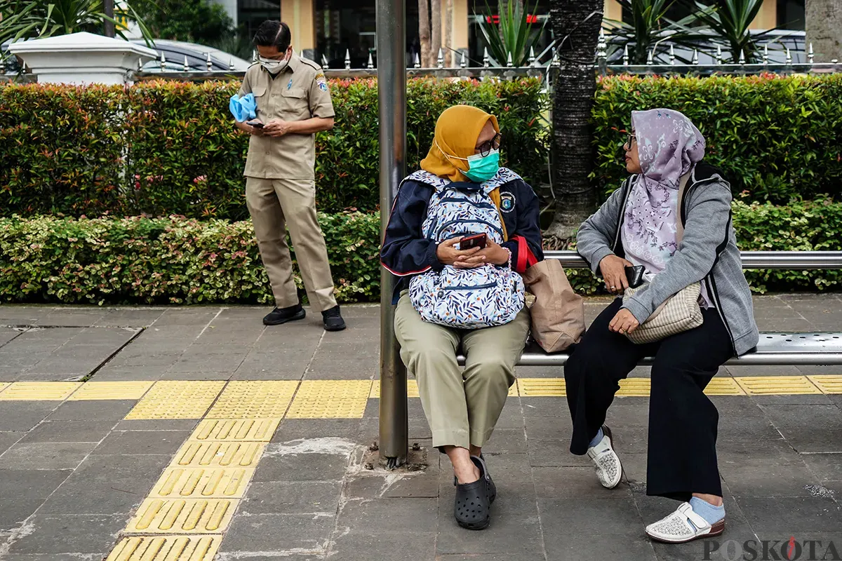 Sejumlah pegawai Aparatur Sipil Negara (ASN) menunggu kedatangan bus pada jam pulang kerja di Halte DPRD di depan komplek perkantoran Balaikota Pemerintah Provinsi (Pemprov) Jakarta, Jakarta, Senin, 24 Maret 2025. (Sumber: Poskota/Bilal Nugraha Ginanjar)