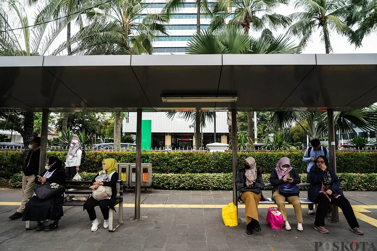 Sejumlah pegawai Aparatur Sipil Negara (ASN) menunggu kedatangan bus pada jam pulang kerja di Halte DPRD di depan komplek perkantoran Balaikota Pemerintah Provinsi (Pemprov) Jakarta, Jakarta, Senin, 24 Maret 2025. (Sumber: Poskota/Bilal Nugraha Ginanjar)