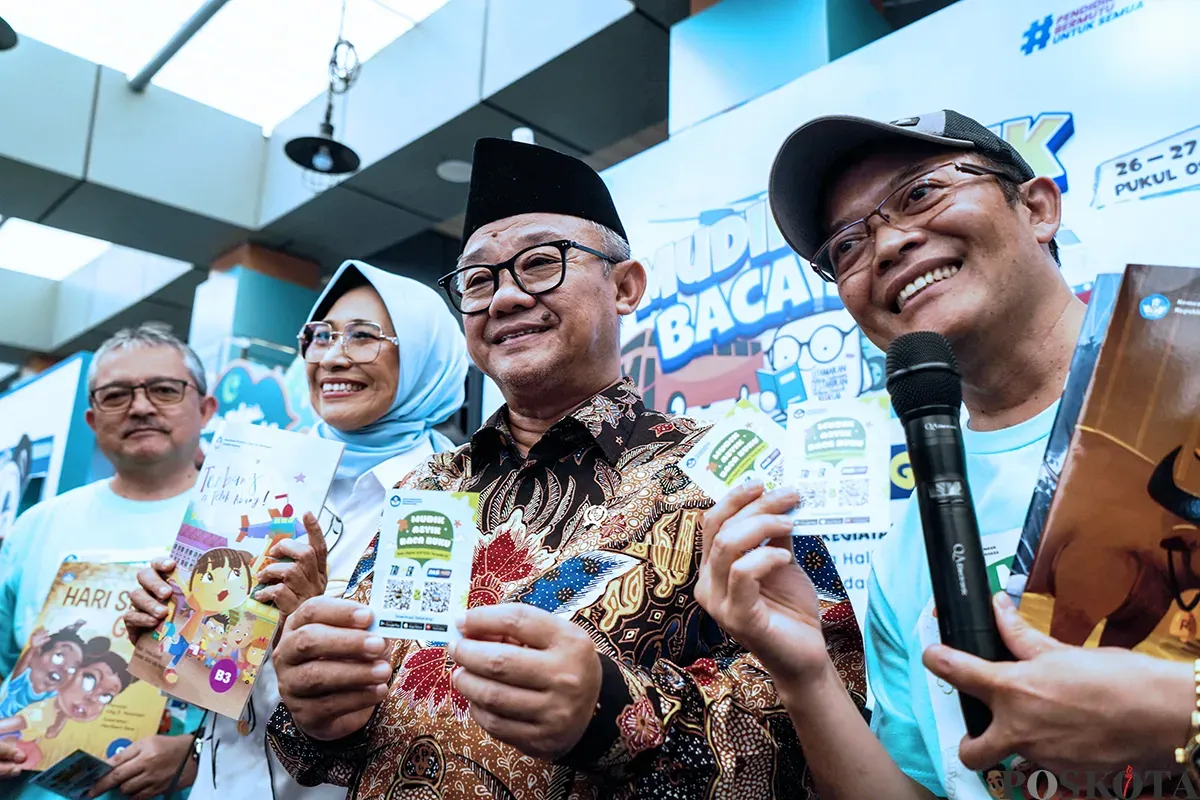Menteri Pendidikan Dasar dan Menengah, Abdul Mu'ti, membagikan buku kepada anak-anak saat peluncuran program Mudik Asyik Baca Buku di Stasiun Pasar Senen, Jakarta, Rabu, 25 Maret 2025. (Sumber: Poskota/Bilal Nugraha Ginanjar)