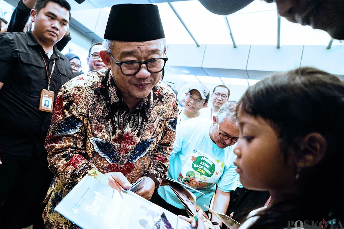 Menteri Pendidikan Dasar dan Menengah, Abdul Mu'ti, membagikan buku kepada anak-anak saat peluncuran program Mudik Asyik Baca Buku di Stasiun Pasar Senen, Jakarta, Rabu, 25 Maret 2025. (Sumber: Poskota/Bilal Nugraha Ginanjar)