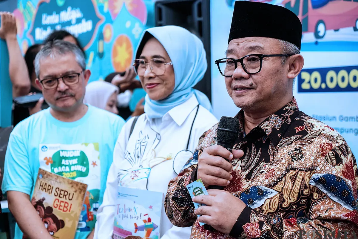 Menteri Pendidikan Dasar dan Menengah, Abdul Mu'ti, membagikan buku kepada anak-anak saat peluncuran program Mudik Asyik Baca Buku di Stasiun Pasar Senen, Jakarta, Rabu, 25 Maret 2025. (Sumber: Poskota/Bilal Nugraha Ginanjar)