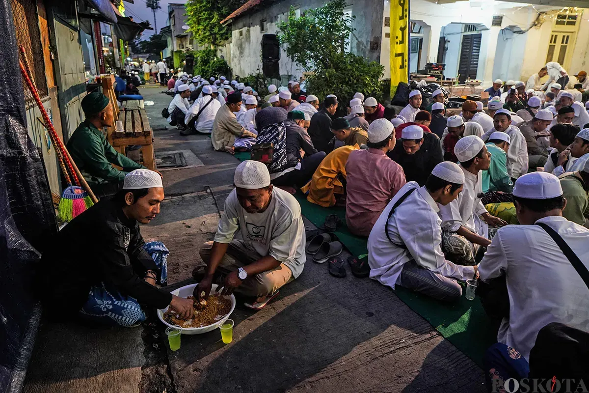 Sejumlah warga berkumpul untuk bersiap berbuka puasa bersama di area pelataran masjid Azzawiyah, dan Masjid Jami’ Annawier di Kampung Arab, Pekojan, Jakarta Barat, Rabu, 26 Maret 2025. (Sumber: Poskota/Bilal Nugraha Ginanjar)