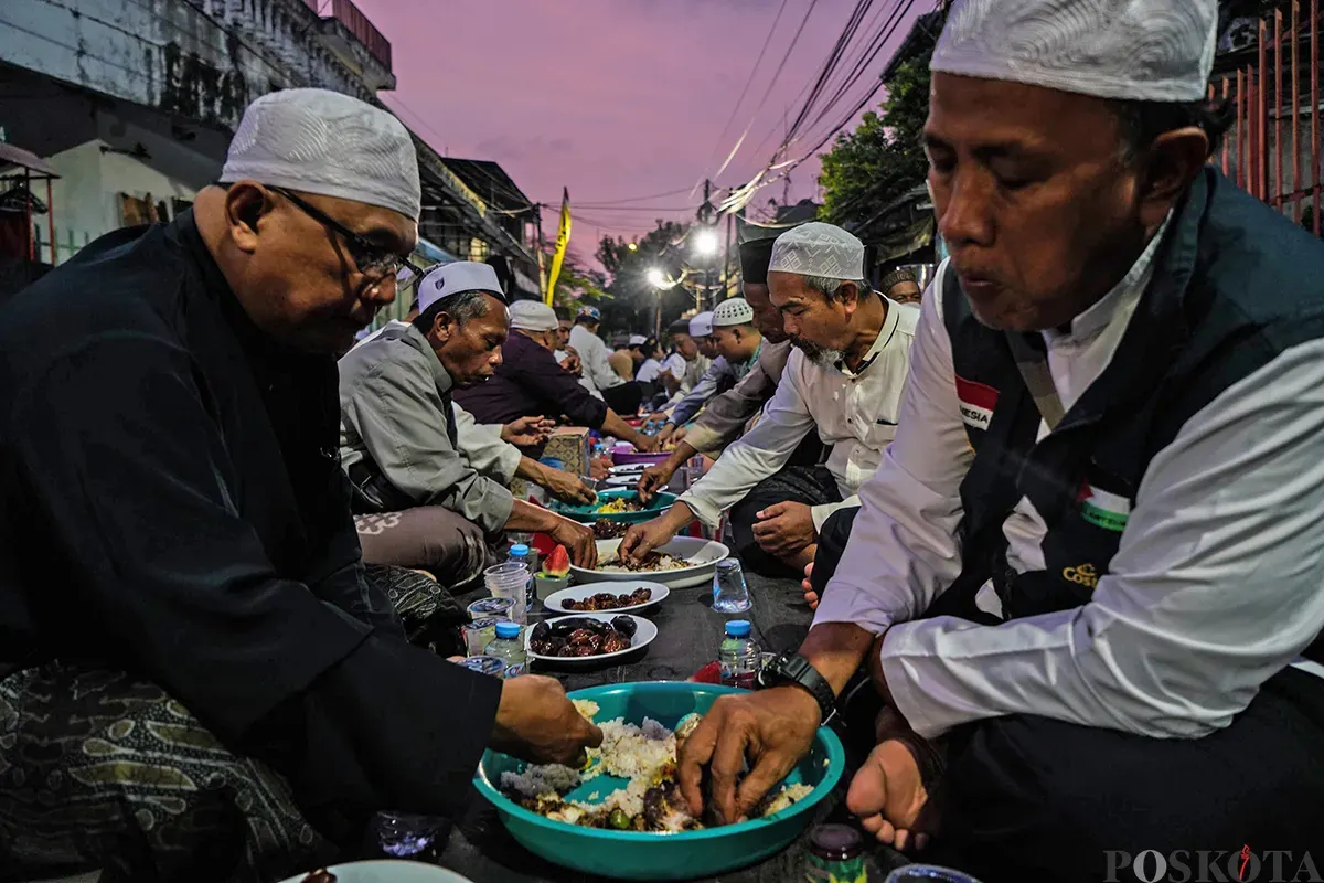 Sejumlah warga berkumpul untuk bersiap berbuka puasa bersama di area pelataran masjid Azzawiyah, dan Masjid Jami’ Annawier di Kampung Arab, Pekojan, Jakarta Barat. (Sumber: Poskota/Bilal Nugraha Ginanjar)