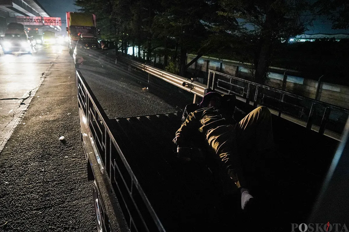 Pemudik beristirahat di pinggir jalan tol sambil melaksanakan sahur di area Tol Cikampek KM 28, Kabupaten Bekasi, Jawa Barat, 28 Maret 2025. (Sumber: Poskoata/ Bilal Nugraha Ginanjar)