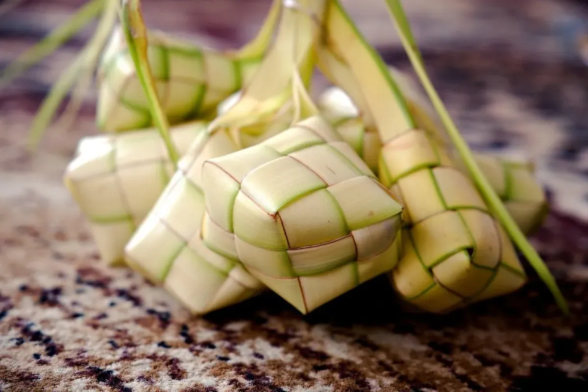 Terbuat dari daun kelapa muda (janur), ketupat merupakan simbol khas dalam tradisi kuliner Indonesia, khususnya saat perayaan Idulfitri. Hidangan ini biasanya diisi dengan beras dan direbus hingga matang. (Sumber: Pixabay/ignartonosbg)