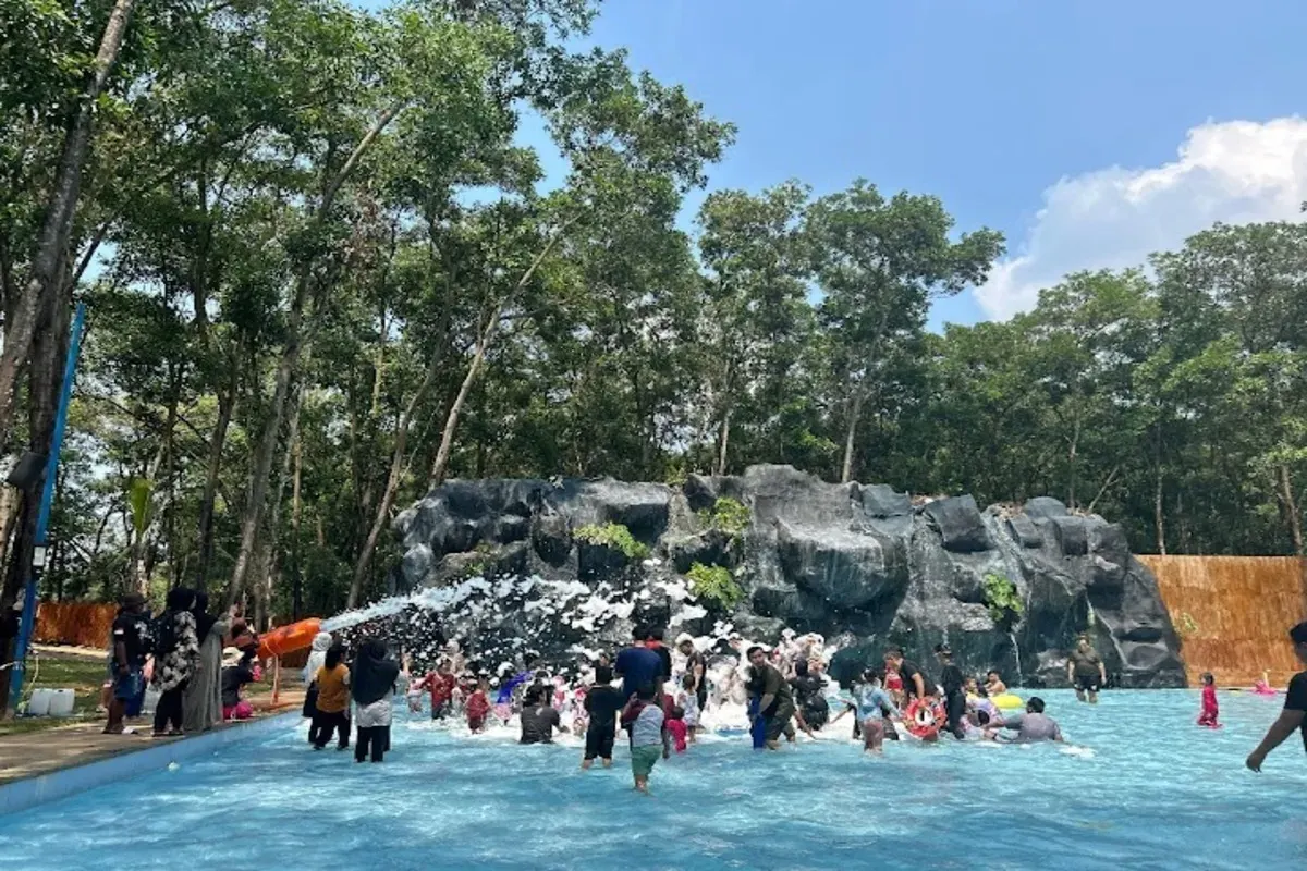 Pengunjung menikmati wahana mandi busa di Nimo Water Forest, Purwakarta, yang dikelilingi pepohonan rindang. Destinasi wisata ini menawarkan sensasi berenang dengan suasana tropis di tengah alam. (Sumber: Google/Rena Jayanti)