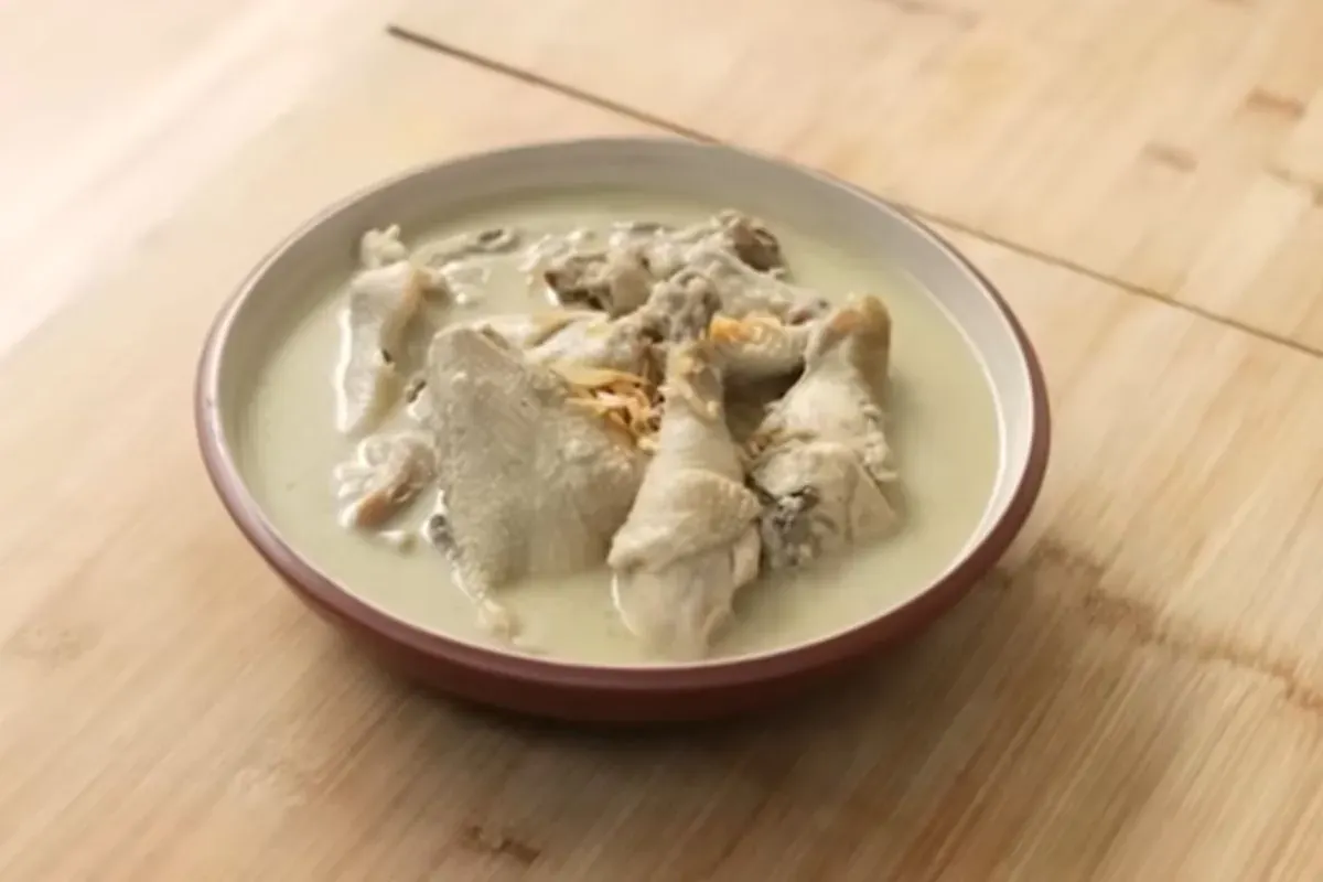 Tangkapan layar hidangan opor ayam putih dengan kuah santan yang gurih dan lezat, cocok disajikan sebagai hidangan khas saat Lebaran atau acara keluarga. (Sumber: YouTube/Devina Hermawan)