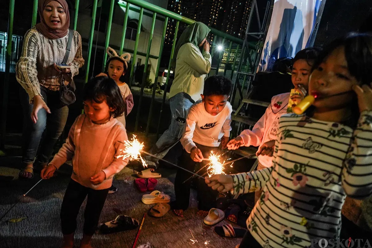 Warga menabuh bedug seraya menyalakan kembang api kerika melakukan pawai takbir keliling menggunakan kendaraan truk terbuka dan panggung warga di Jalan KH Mas Mansyur, Kebon Kacang, Tanah Abang, Jakarta, Minggu, 30 Maret 2025. (Sumber: Poskoata/ Bilal Nugraha Ginanjar)