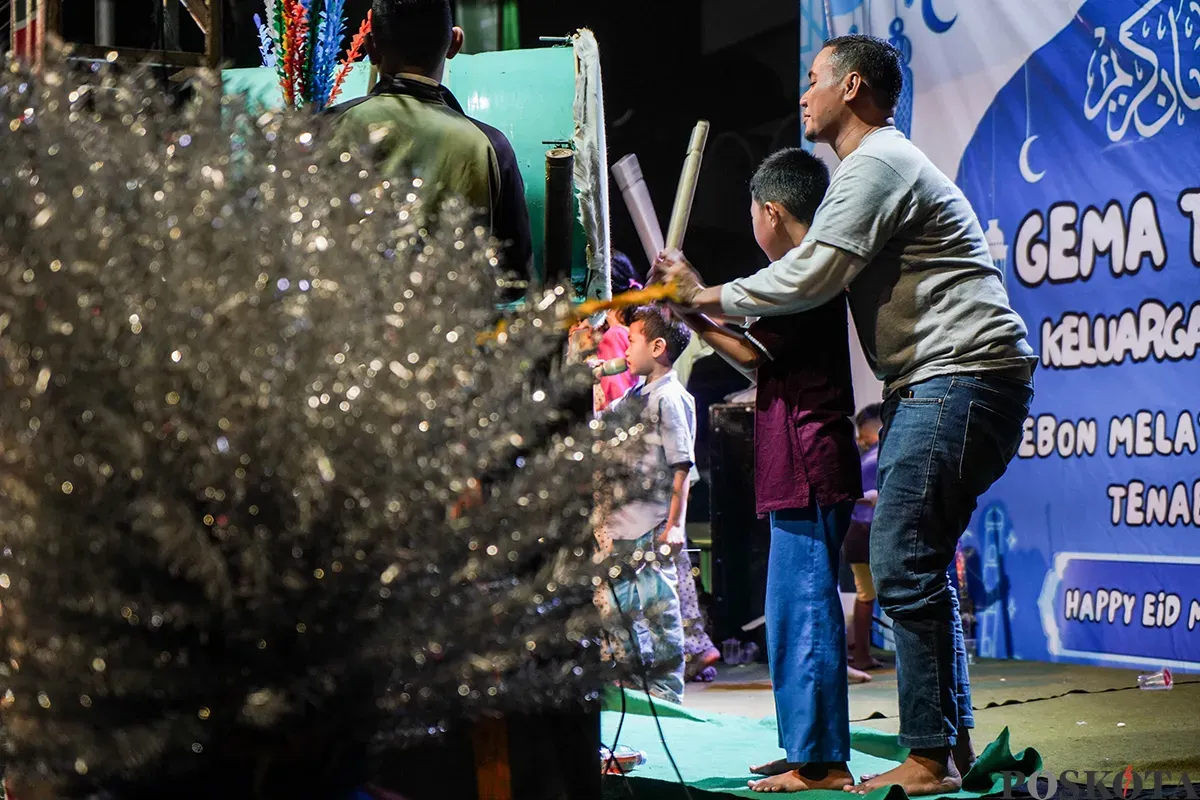 Warga menabuh bedug seraya menyalakan kembang api kerika melakukan pawai takbir keliling menggunakan kendaraan truk terbuka dan panggung warga di Jalan KH Mas Mansyur, Kebon Kacang, Tanah Abang, Jakarta, Minggu, 30 Maret 2025. (Sumber: Poskoata/ Bilal Nugraha Ginanjar)