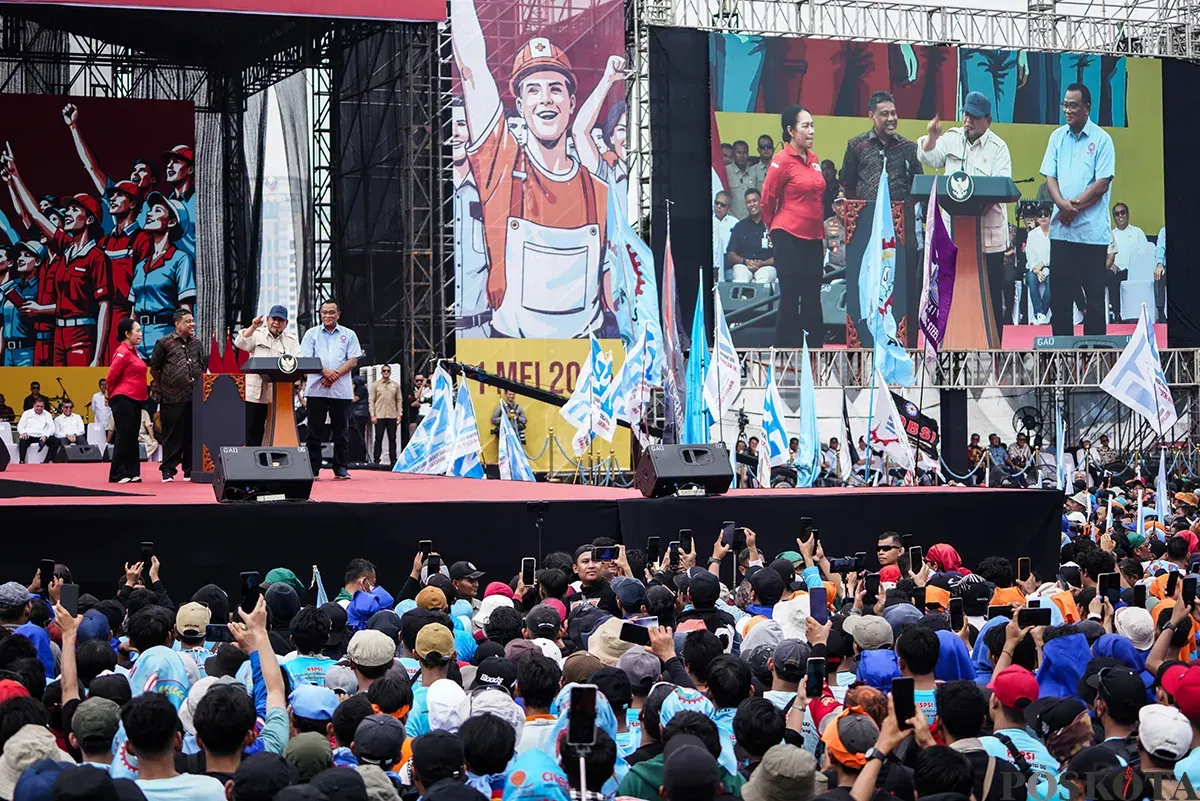 Presiden RI Prabowo Subianto berbicara dari podium di depan ribuan massa buruh yang tergabung dari berbagai serikat kerja memadati kawasan Monumen Nasional (Monas), Jakarta, untuk memperingai Hari Buruh Internasional pada Kamis, 1 Mei 2025. (Sumber: Poskota/Bilal Nugraha Ginanjar)