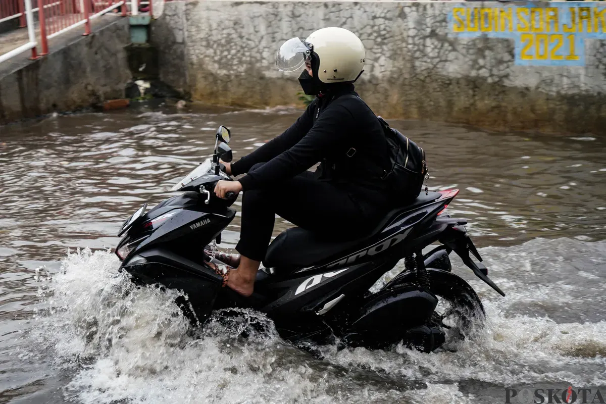 Pengendara motor melintasi genangan banjir di Jalan Pondok Karya, Jakarta Selatan, Rabu, 7 Mei 2025. (Sumber: Poskota/Bilal Nugraha Ginanjar)