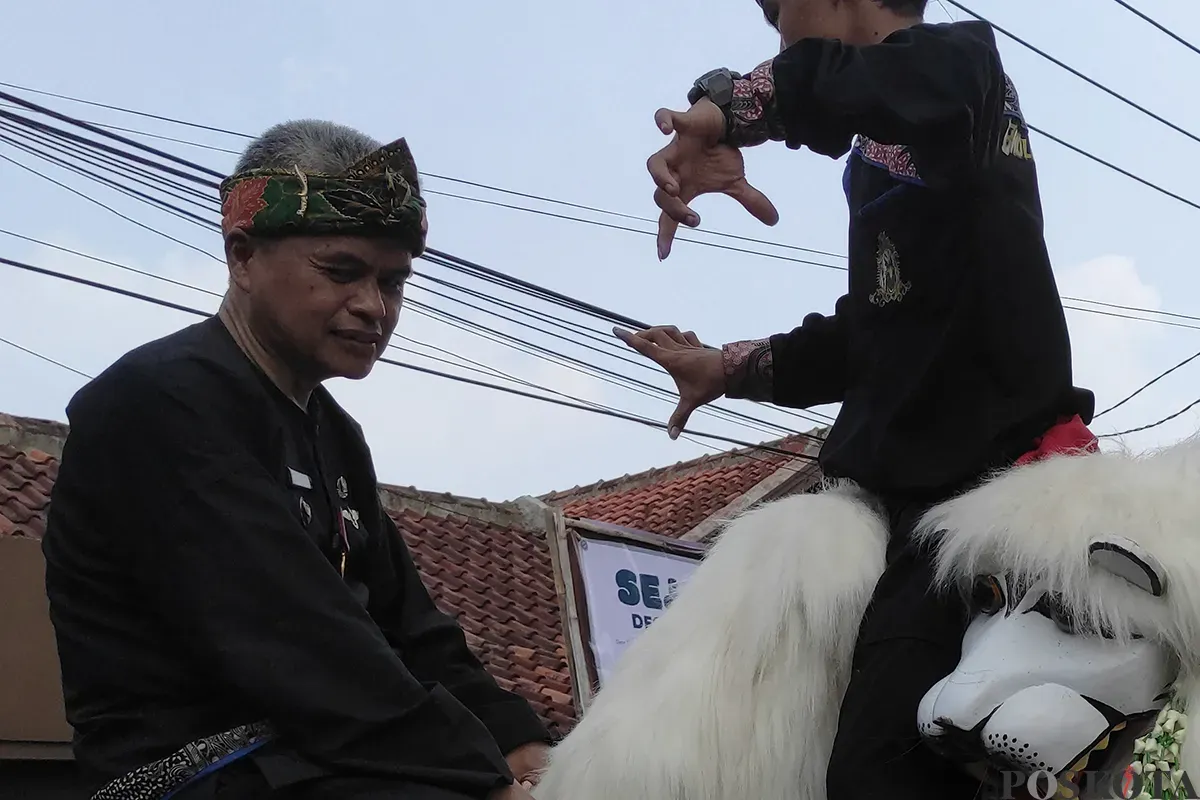 Sejumlah seniman lokal yang tergabung dalam beberapa komunitas seni dan budaya, tengah unjuk kebolehannya dalam parade seni daerah di Desa Cibiru Hilir, Cileunyi, Kabupaten Bandung, beberapa waktu lalu. (Sumber: Poskota/Ade Mamad)