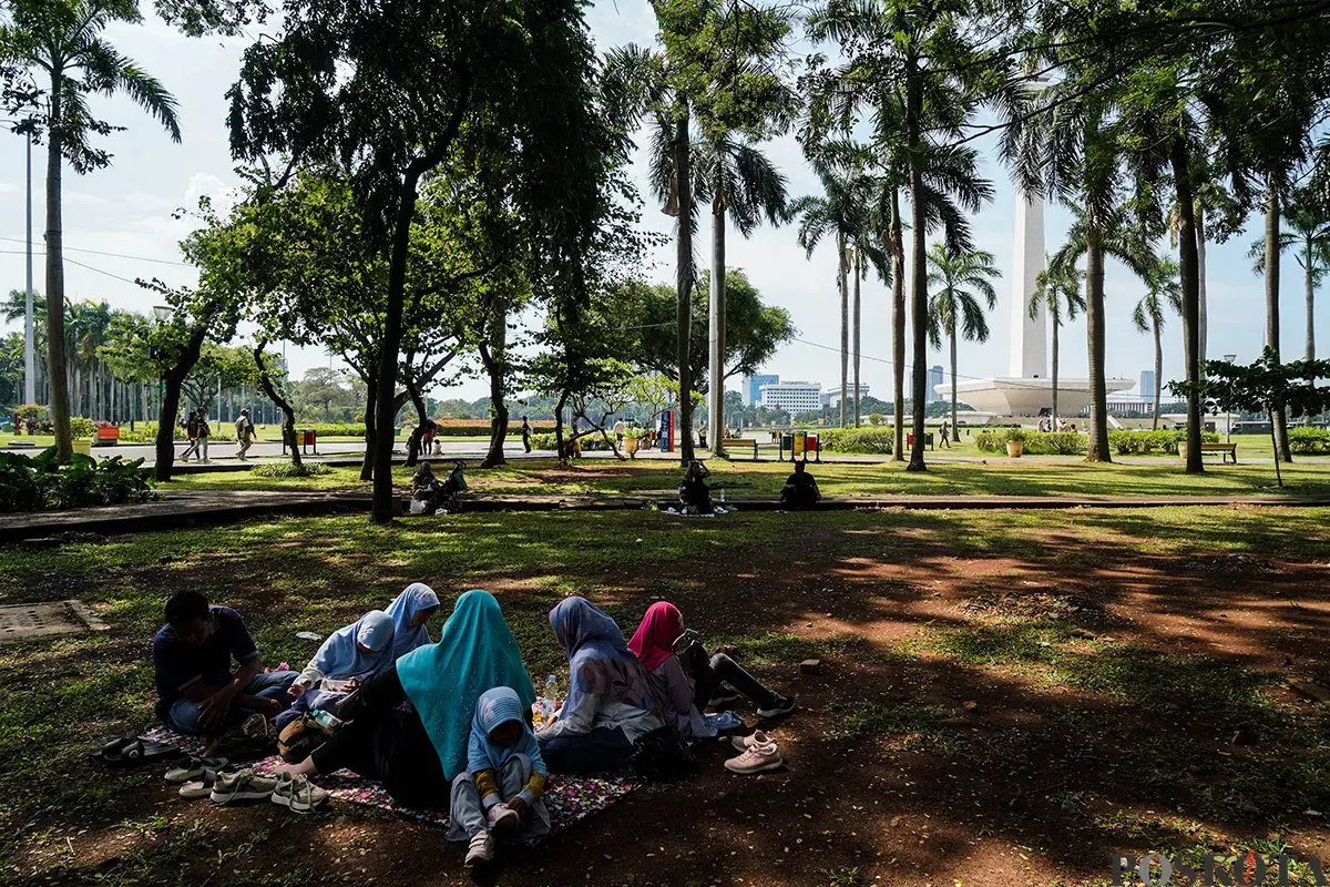 Sejumlah pengunjung menikmati sejumlah fasilitas wisata yang tersedia di kawasan Tugu Monumen Nasional (Monas), Jakarta, Selasa, 13 Mei 2025. (Sumber: Poskota/Bilal Nugraha Ginanjar)
