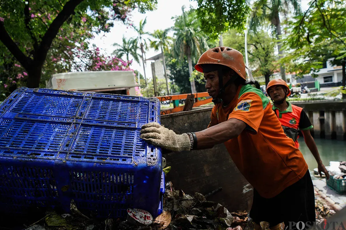 Petugas Unit Penanganan Sampah Badan Air (UPS Badan Air) Kecamatan Tanah Abang membersihkan tumpukan sampah yang mengendap di aliran Kali Cideng, Tanah Abang, Jakarta, Selasa, 13 Mei 2025. (Sumber: Poskota/Bilal Nugraha Ginanjar)