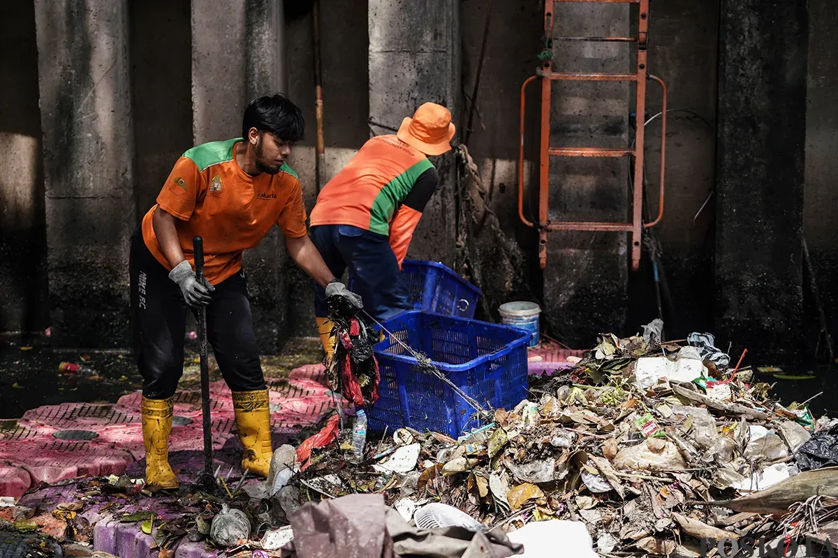 Petugas Unit Penanganan Sampah Badan Air (UPS Badan Air) Kecamatan Tanah Abang membersihkan tumpukan sampah yang mengendap di aliran Kali Cideng, Tanah Abang, Jakarta, Selasa, 13 Mei 2025. (Sumber: Poskota/Bilal Nugraha Ginanjar)