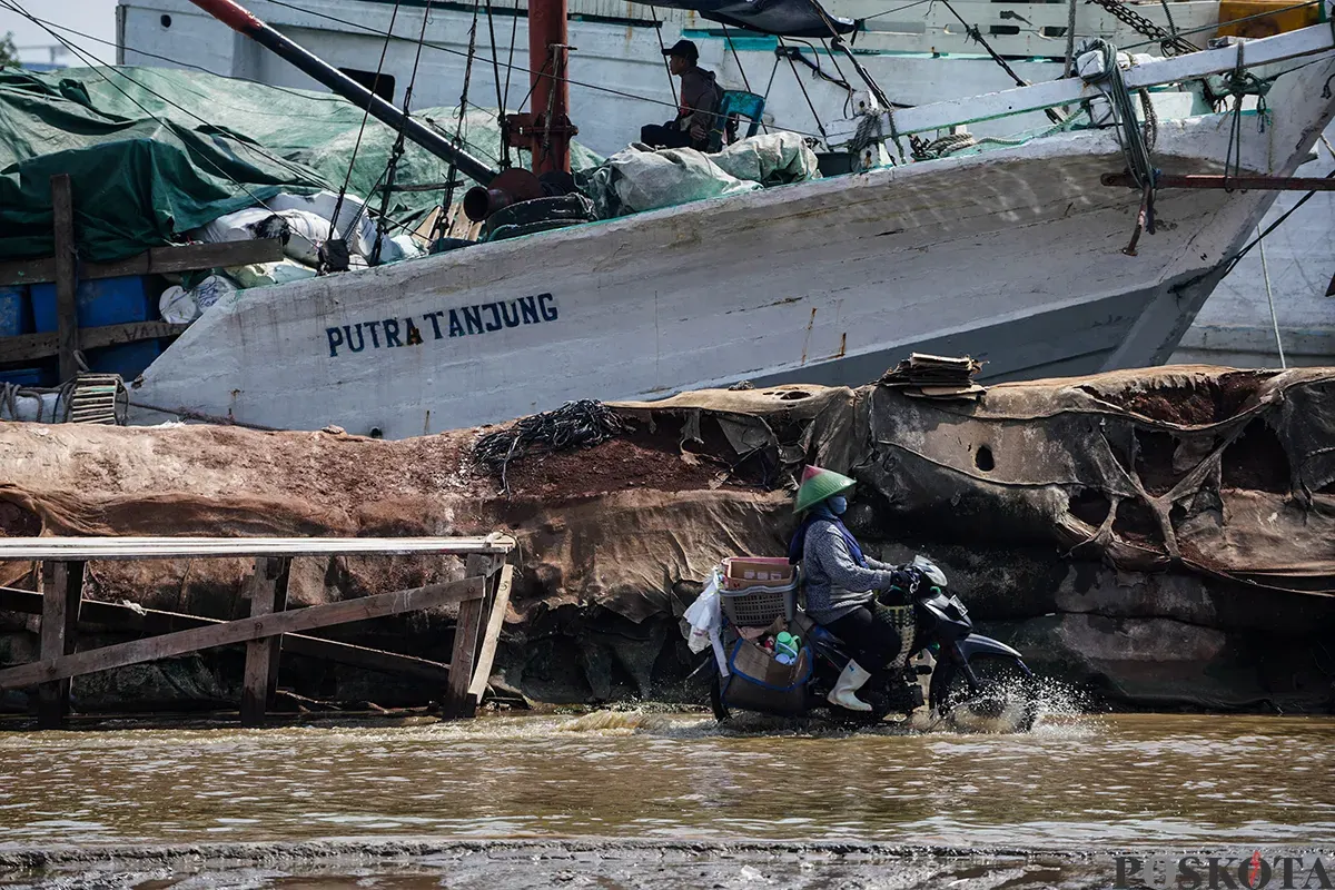 Sejumlah kendaraan berupaya melintasi jalan yang tergenang banjir rob di kawasan Pelabuhan Sunda Kelapa, Jakarta Utara, Rabu, 14 Mei 2025. (Sumber: Poskota/Bilal Nugraha Ginanjar)