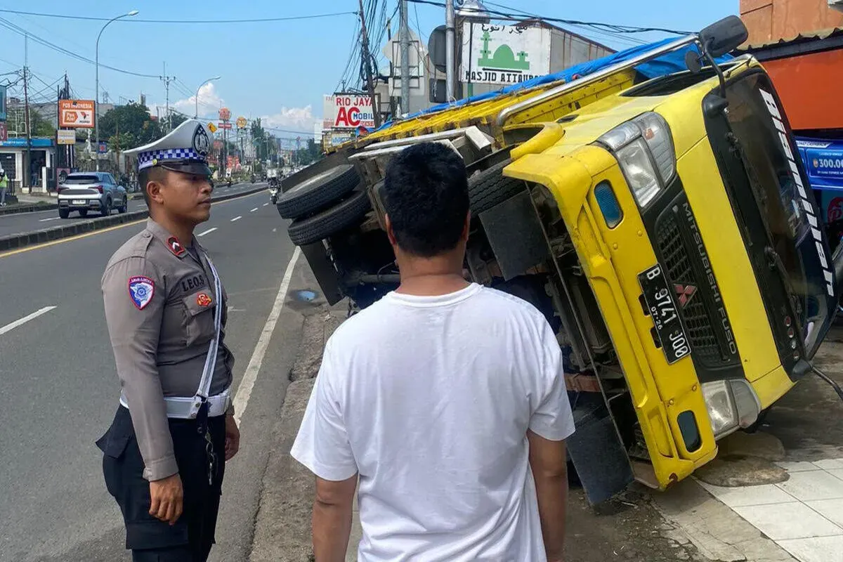 Satu unit truk bermuatan bahan bangunan anjlok ke dalam gorong-gorong depan salah satu toko di Bojongsari, Kota Depok, Rabu, 14 Mei 2025. (Sumber: Polsek Bojongsari)