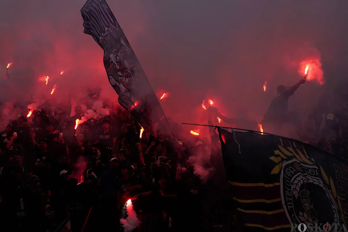 Suporter Persita Tangerang saat menyalakan flare di tribun penonton. (Sumber: Poskota/Bilal Nugraha Ginanjar)