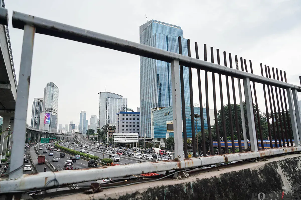 Warga berjalan diatas Jembatan Penyebrangan Orang (JPO) di depan Gedung Smesco, Jalan Gatot Subroto, Jakarta Selatan, tak terawat, Minggu, 25 Mei 2025. (Sumber: Poskota/Bilal Nugraha Ginanjar)