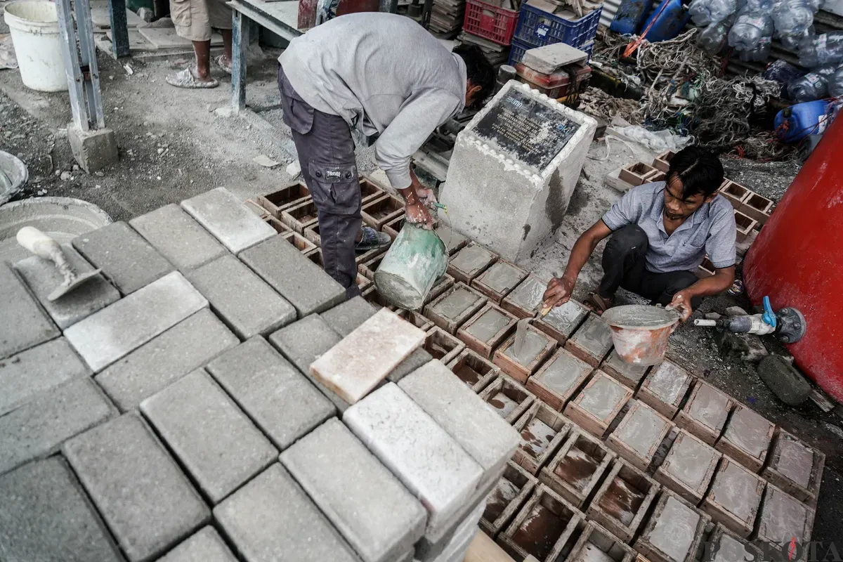 Pekerja mengerjakan proses pembuatan adonan kerajinan berbahan dasar limbah cangkang kerang hijau di Rumah Produksi Kelompok Kerajinan Cangkang Kering (Cangkring), Cilincing, Jakarta Utara, Senin, 26 Mei 2025. (Sumber: Poskota/Bilal Nugraha Ginanjar)
