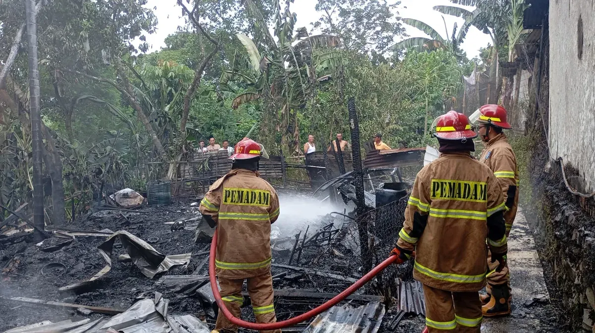 Petugas Damkar Depok melakukan pendinginan di lapak barang bekas yang hangus terbakar hingga rata dengan tanah. (Sumber: Istimewa)