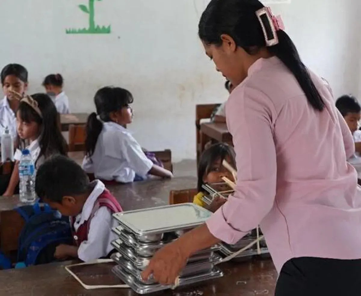 Seorang guru membagikan baki makanan kepada para siswa di SD Katolik Wee Pangali, Sumba Barat Daya, sebagai bagian dari program Makan Bergizi Gratis (MBG) yang mendorong kehadiran dan semangat belajar anak-anak. (Sumber: Istimewa)