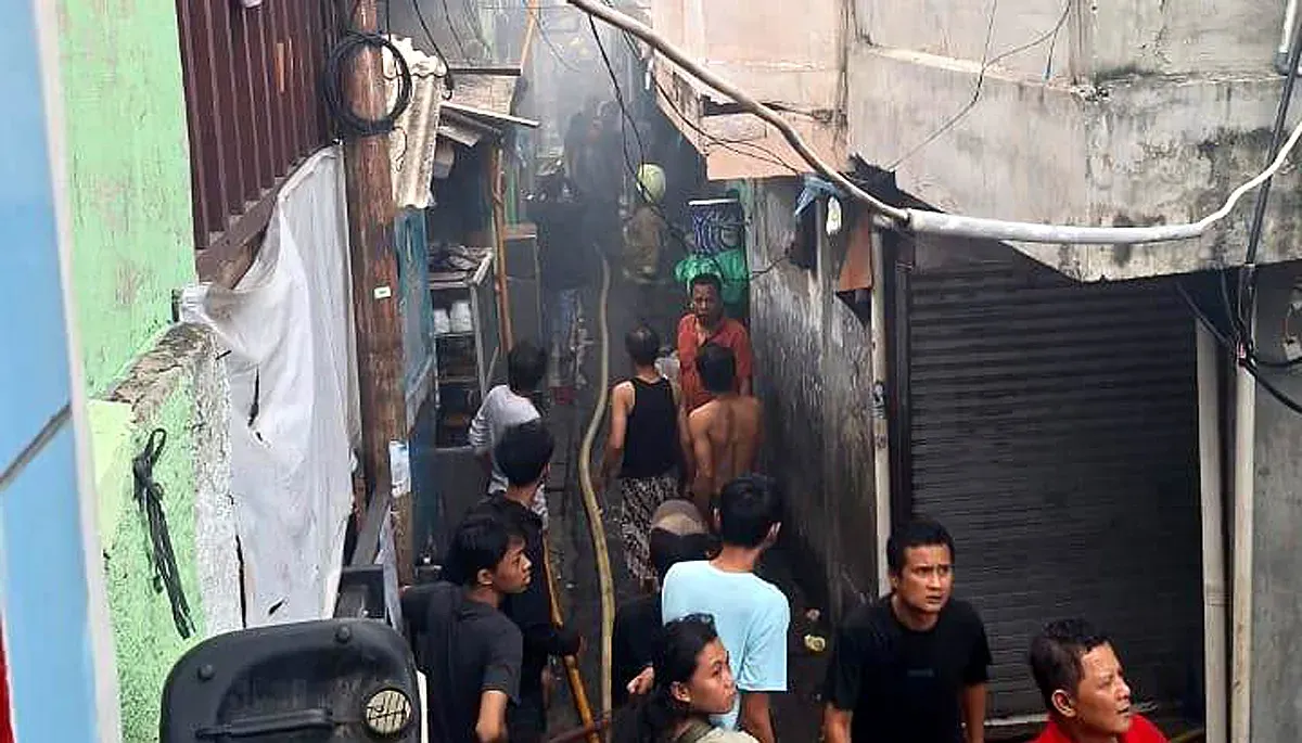 Petugas damkar berjibaku memadamkan api yang membakar sebuah rumah di Gang Pelita, Kelurahan Jatipulo, Palmerah, Jakarta Barat, Minggu, 16 November 2025. (Sumber: Dok Gulkarmat Jakarta Barat)