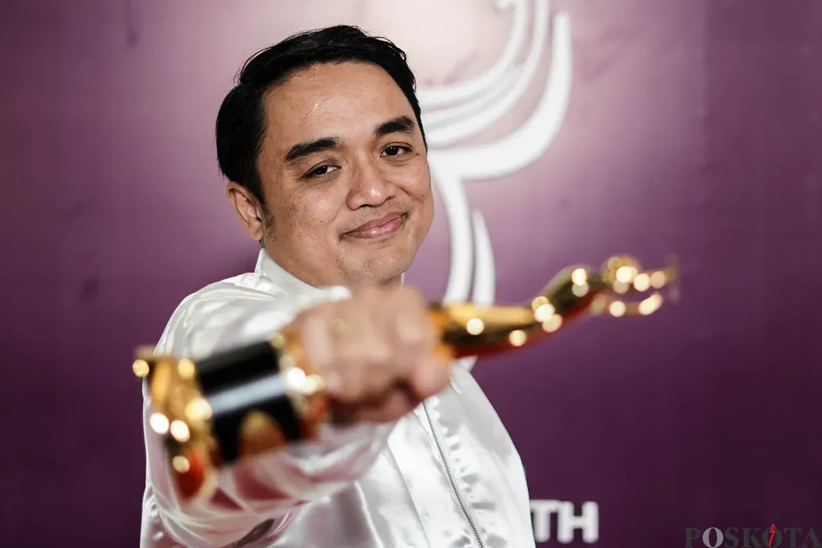 Komposer musik Dipha Barus berpose dengan piala saat menghadiri malam Anugerah Musik Indonesia (AMI) Award 2025 di Jakarta, Rabu, 19 November 2025. (Sumber: Poskota/Bilal Nugraha Ginanjar)