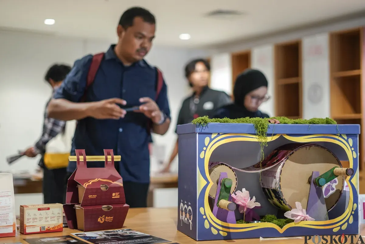 Pengunjung mengamati karya desain grafis pada pameran ADGI Design Week 2025 di Taman Ismail Marzuki, Jakarta, Minggu, 23 November 2025. (Sumber: Poskota/Bilal Nugraha Ginanjar)