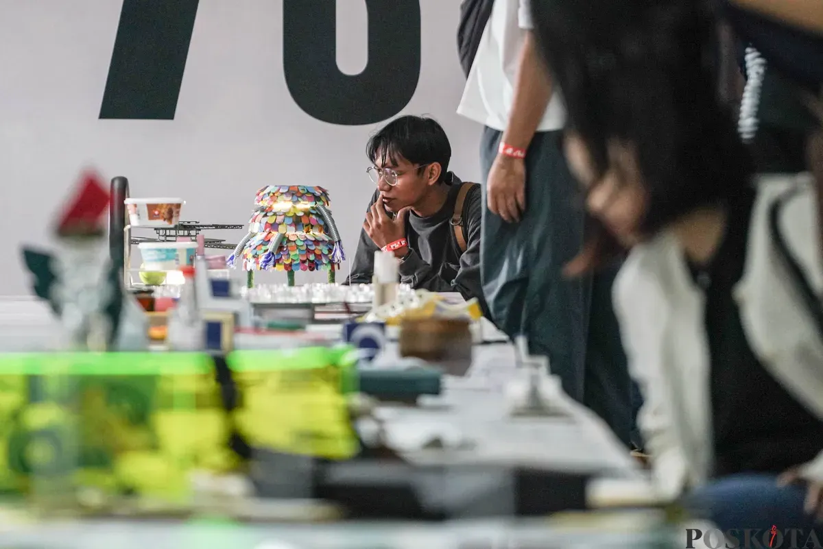 Pengunjung mengamati karya desain grafis pada pameran ADGI Design Week 2025 di Taman Ismail Marzuki, Jakarta, Minggu, 23 November 2025. (Sumber: Poskota/Bilal Nugraha Ginanjar)