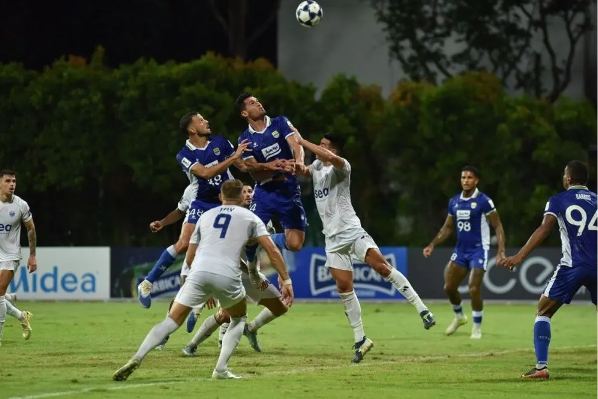 Pemain Persib Bandung melakukan duel udara pada pertandingan melawan Lion City Sailors, Rabu 26 November 2025. (Sumber: persib.co.id)