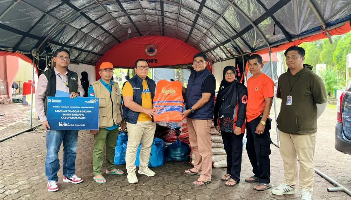 Corporate Secretary Bank Mandiri, M Ashidiq Iswara (ketiga dari kiri) menyerahkan bantuan untuk warga terdampak bencana alam di Sumatera. (Sumber: Corsec Bank Mandiri)