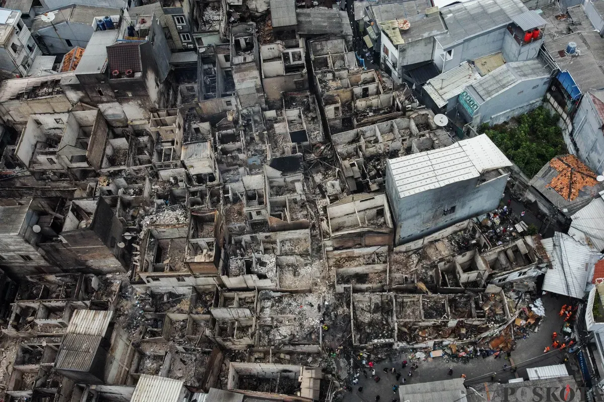 Warga berjalan di antara puing-puing sisa kebakaran rumah di pemukiman padat penduduk Taman Sari, Jakarta Barat, Senin, 29 September 2025. (Sumber: Poskota/Bilal Nugraha Ginanjar)