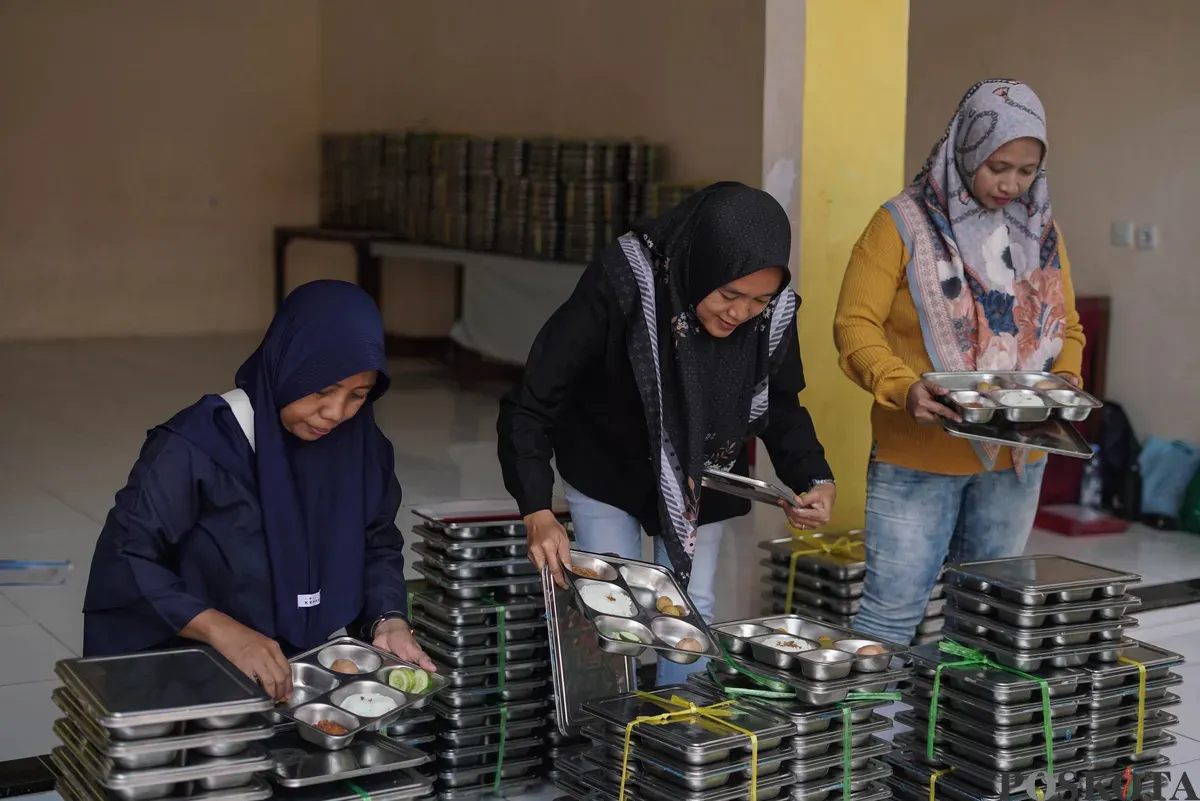 Orang tua murid mendistribusikan Makan Bergizi Gratis (MBG) kepada siswa di SDN Pejaten Barat 1 Pagi, Jakarta Selatan, Selasa, 30 September 2025. (Sumber: Poskota/Bilal Nugraha Ginanjar)