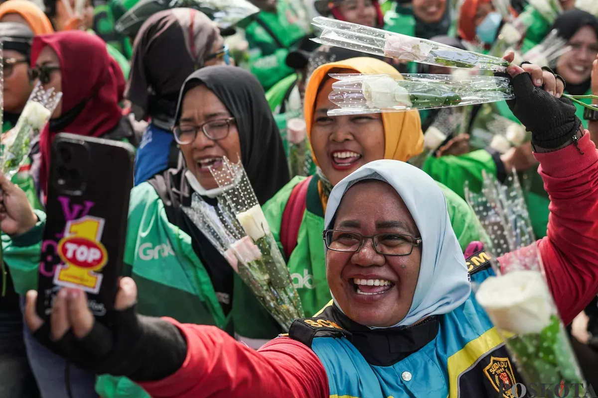Sejumlah pengemudi ojek daring (ojol) membagikan bunga kepada petugas di kawasan Monumen Nasional, Jakarta, Selasa, 2 September 2025. (Sumber: Poskota/Bilal Nugraha Ginanjar)