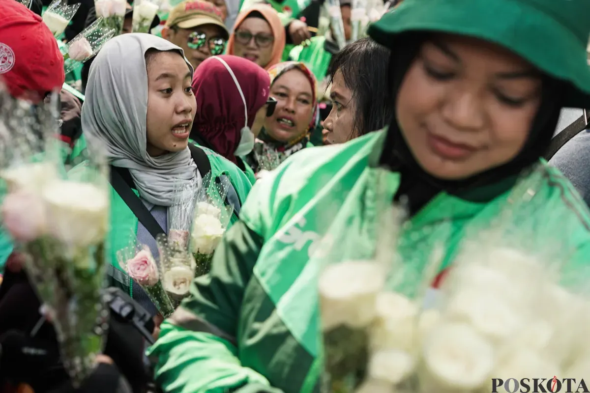 Sejumlah pengemudi ojek daring (ojol) membagikan bunga kepada petugas di kawasan Monumen Nasional, Jakarta, Selasa, 2 September 2025. (Sumber: Poskota/Bilal Nugraha Ginanjar)