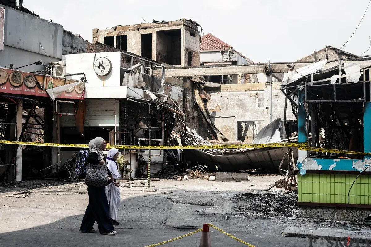 Warga mengamati area pusat jajanan serba ada (Pujasera) pascakebakaran di Jalan RS Fatmawati Raya, Gandaria Selatan, Jakarta, Senin, 8 September 2025. (Sumber: Poskota/Bilal Nugraha Ginanjar)
