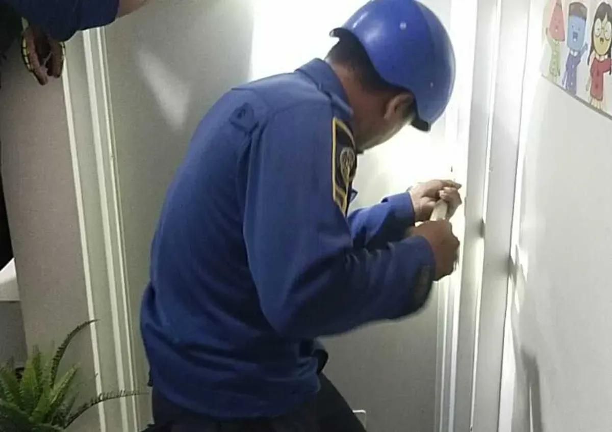 Petugas Damkar Kabupaten Bogor mencoba membuka pintu kamar mandi yang terkunci, untuk mengevakuasi pelajar yang terjebak. (Sumber: Damkar)