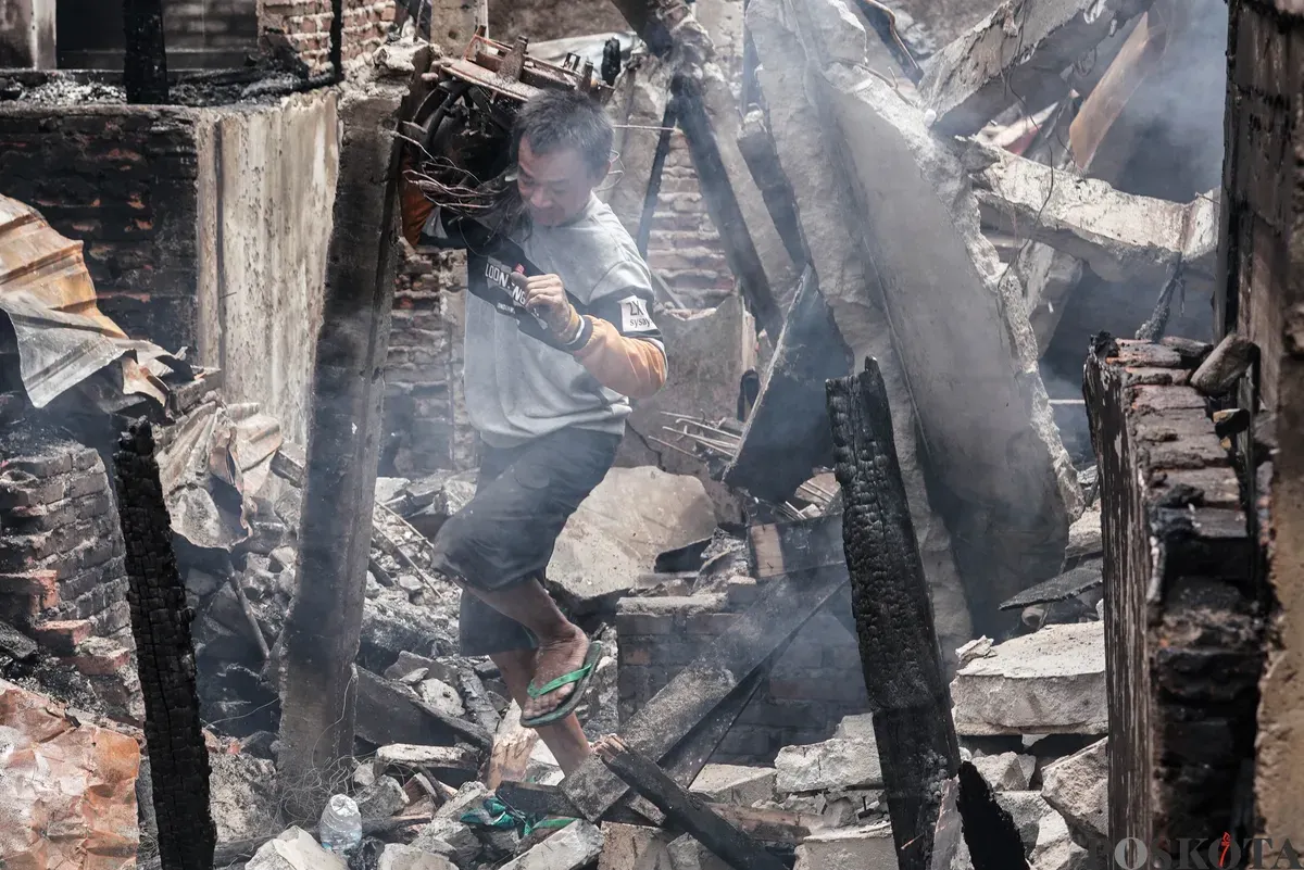 Warga membawa barang-barang yang masih bisa diselamatkan dari kebakaran di Senen, Jakarta Pusat, Senin, 15 September 2025. (Sumber: Poskota/Bilal Nugraha Ginanjar)