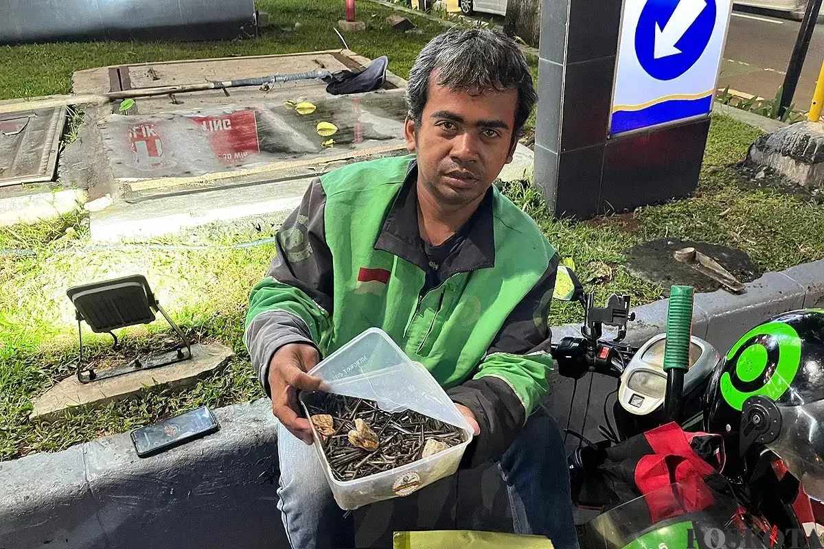 Usmanto, 37 tahun, driver ojol yang juga relawan ranjau paku saat sedang mengambil ranjau paku di Jalan Gatot Subroto, Jakarta Selatan, Senin, 22 September 2025. (Sumber: Poskota/Pandi Ramedhan)