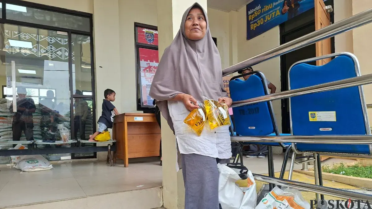 Warga Serua, Nokyani, ibu rumah tangga sangat senang mendapatkan bantuan pangan pemerintah diambil sendiri di kantor Kelurahan Serua. (Sumber: Poskota/Angga Pahlevi)