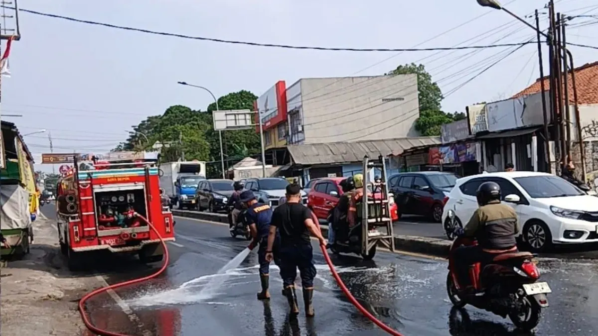 Petugas Damkar Kota Depok membersihkan jalan di Jalan Raya Parung-Ciputat yang terlumuri tumpahan oli. (Sumber: Dok. Istimewa)